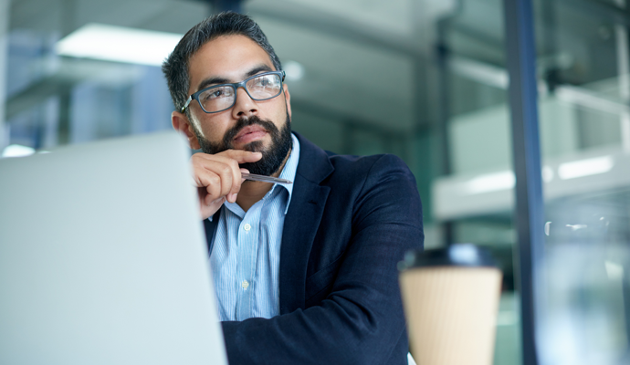 man thinking at computer in office
