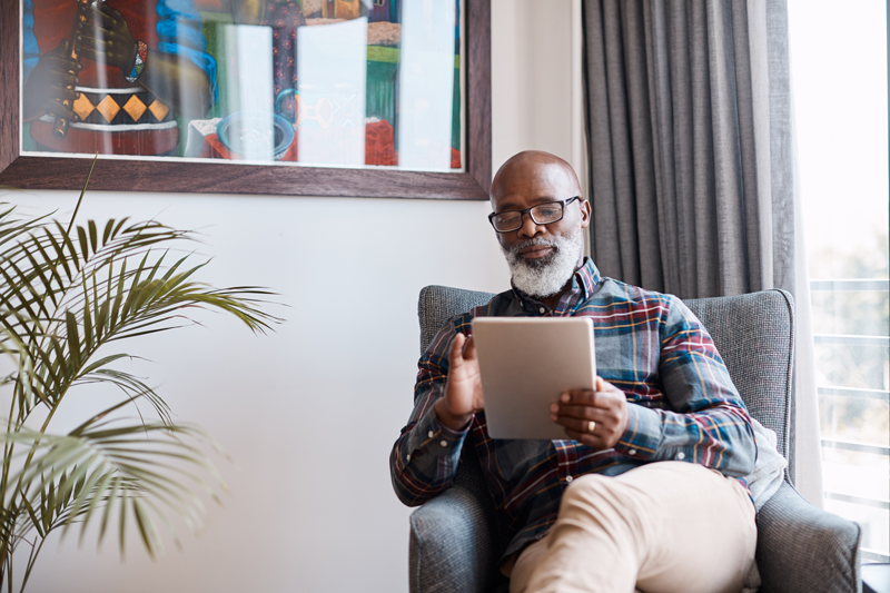 mature man reading a tablet at home