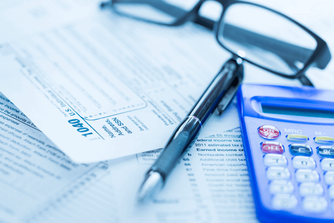tax return papers with pen, glasses and calculator sitting on top