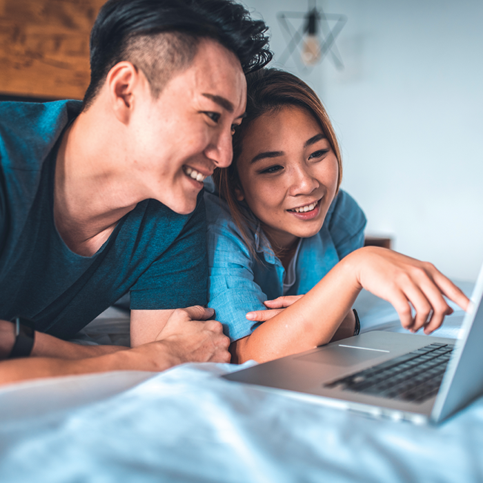 Couple sitting on couch using computer